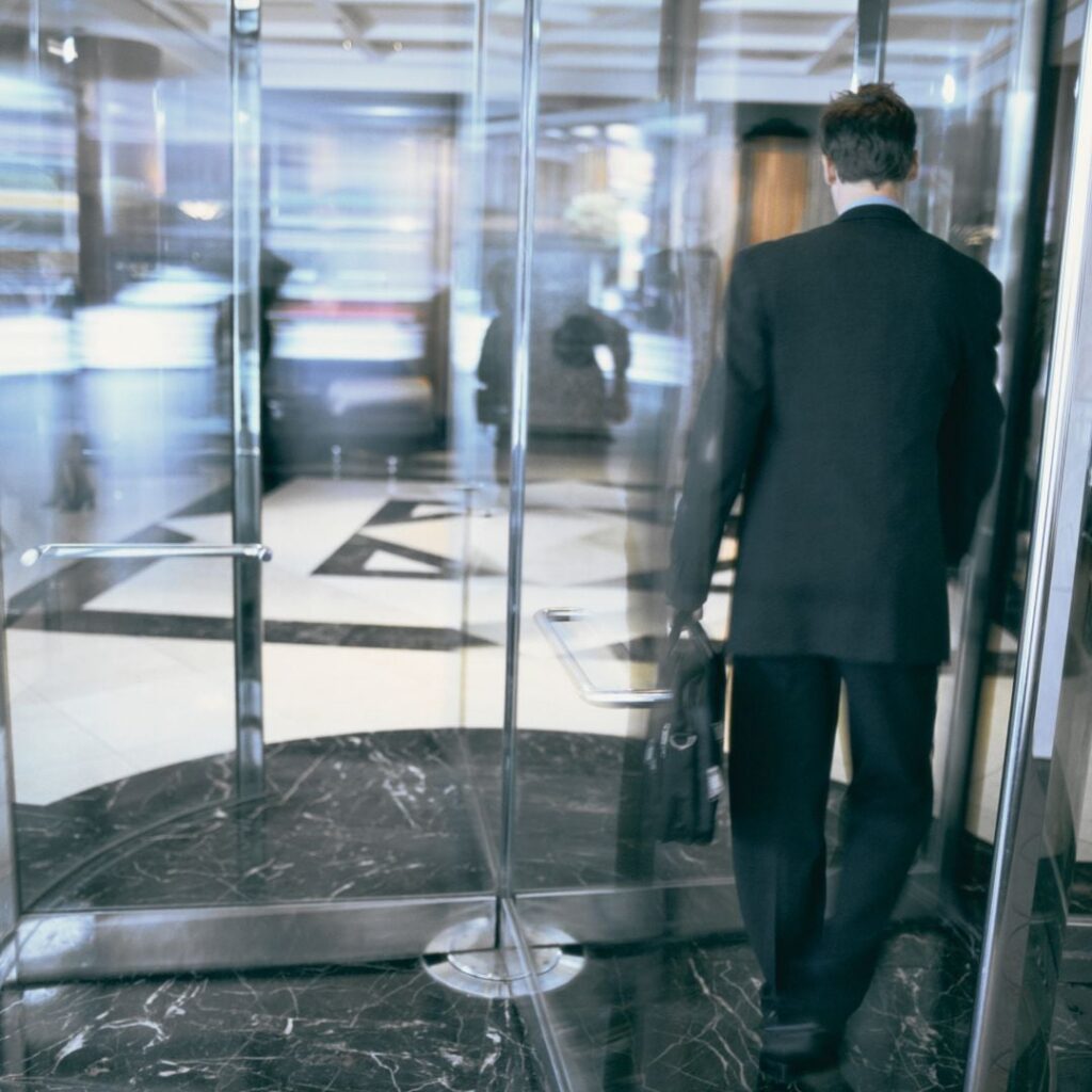 Depiction of financial services and insurance churn as a customer rotates out of a bank entrance.