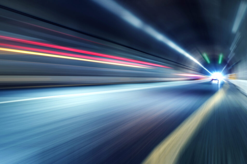 Car lights inside of a tunnel.|