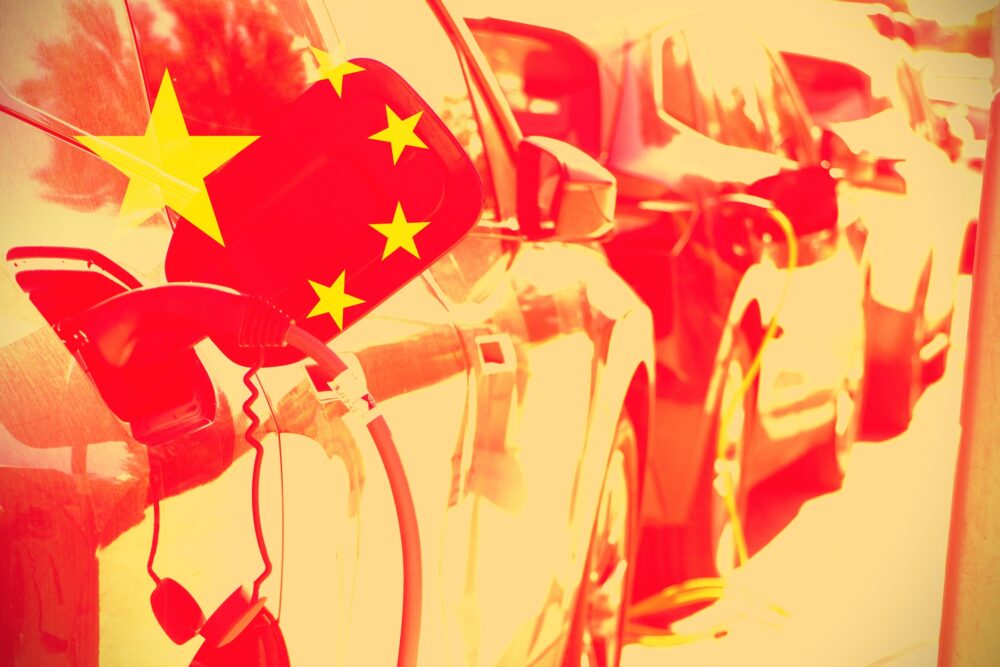 Chinese flag with electric cars as background. Concept of car industry in China.|