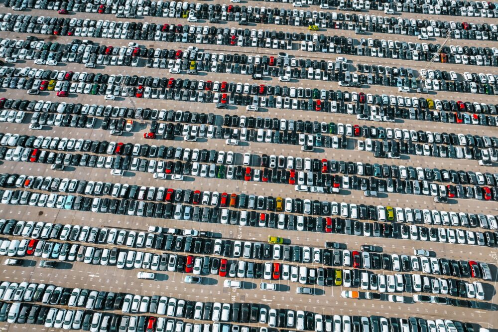Aerial view of the stock of a large number of cars parked with order outside of an automobile company.|