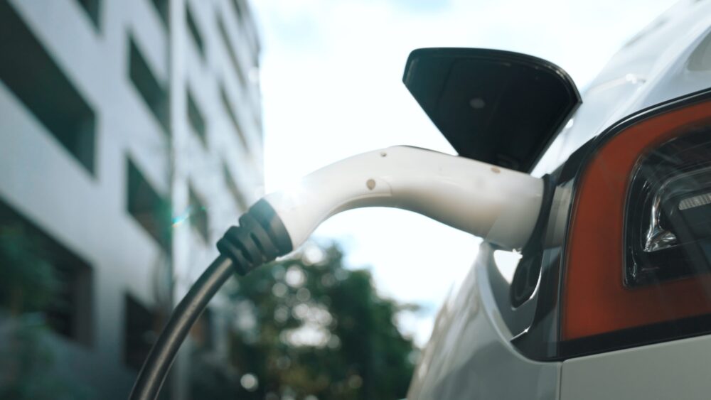 EV electric car charging in green sustainable city outdoor garden in summer. Urban sustainability lifestyle by green clean rechargeable energy of electric BEV vehicle innards|