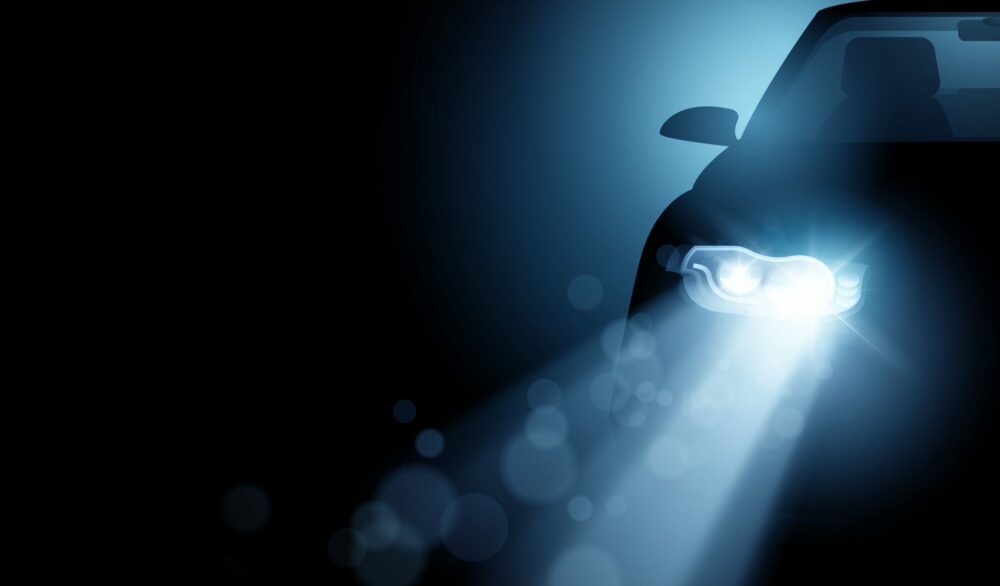 car headlight in the dark|Futuristic graphic of a sportscar speeding in urban highway